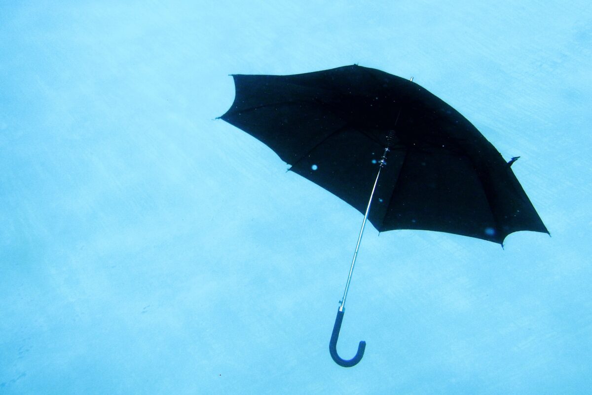 Black umbrella floating, symbolizing balance in productivity and life, aligned with Full Focus's Double Win concept.